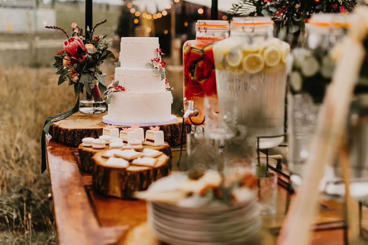 Hochzeitstorte und Süßigkeiten auf Baumscheiben