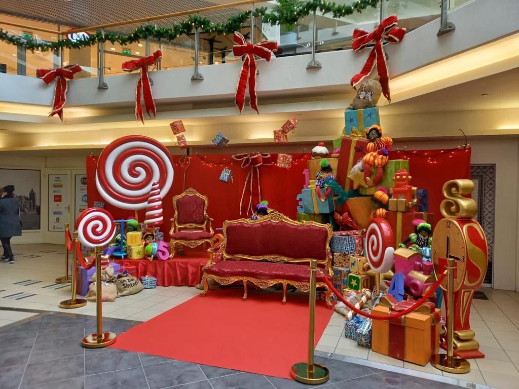Nikolausdekoration mit Hüpfsessel, Geschenken, Lollis und rotem Teppich in einem Einkaufszentrum