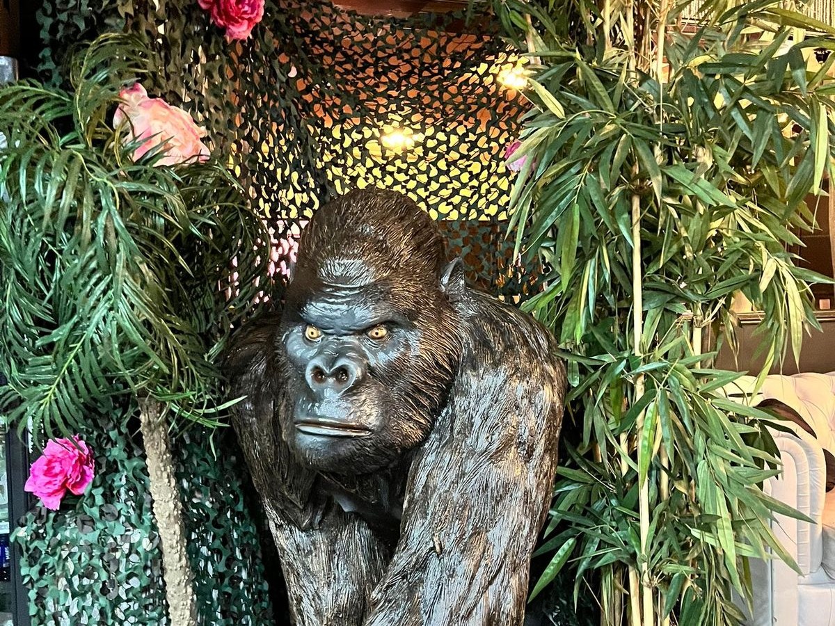 Lebensgroße Gorillafiguren zwischen Bambus und Tarnnetz als Dschungeldekor